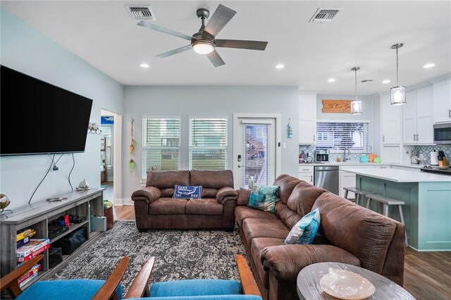 living room with dark wood-type flooring, sink, and ceiling fan