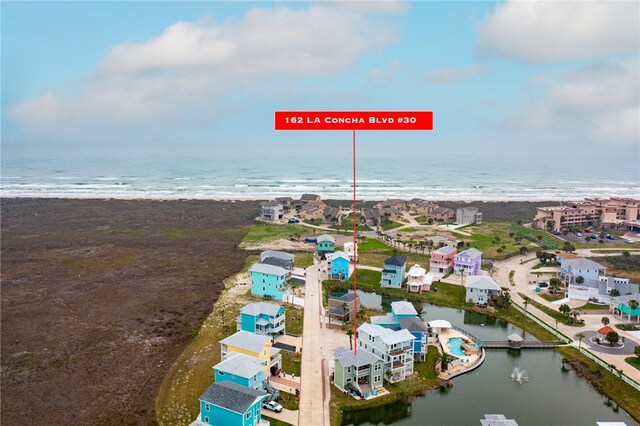 bird's eye view with a water view and a beach view