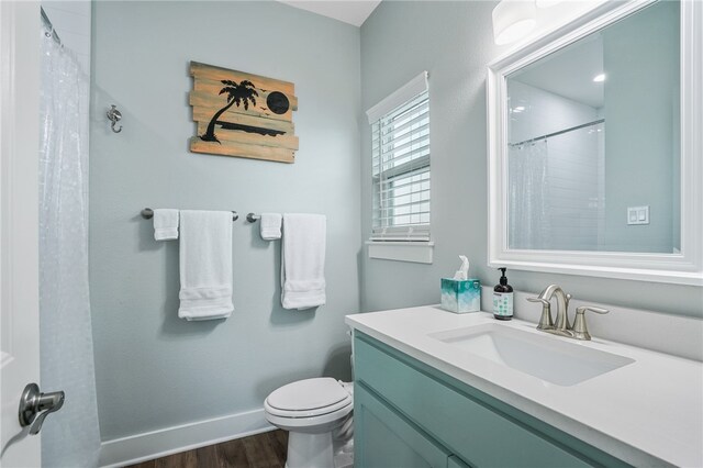 bathroom with toilet, vanity, hardwood / wood-style flooring, and walk in shower