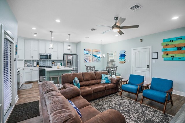 living room with dark wood-type flooring and ceiling fan