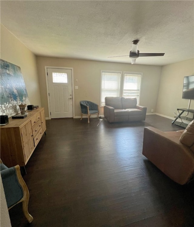 living room with a textured ceiling, dark hardwood / wood-style floors, and ceiling fan