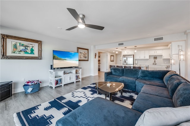 living room with ceiling fan and dark hardwood / wood-style flooring