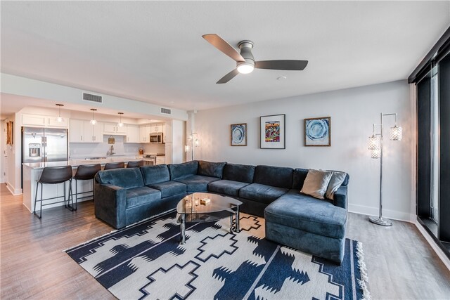 living room featuring hardwood / wood-style floors and ceiling fan