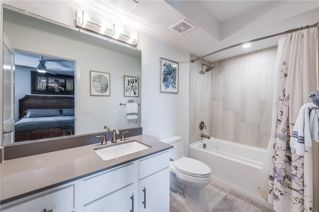 full bathroom with ceiling fan, shower / tub combo with curtain, vanity, tile patterned floors, and toilet