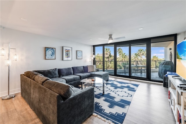 living room featuring hardwood / wood-style floors, ceiling fan, and expansive windows