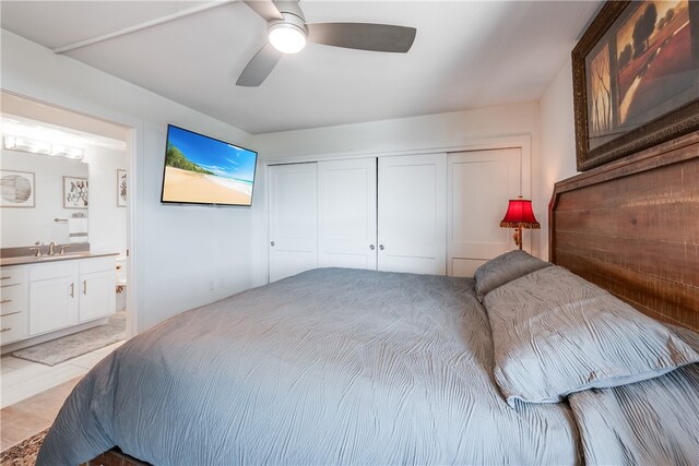 bedroom with ceiling fan, ensuite bath, a closet, and sink