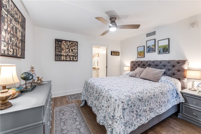 bedroom with dark hardwood / wood-style floors, ceiling fan, and connected bathroom