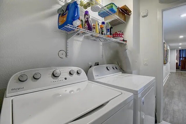 laundry room featuring separate washer and dryer and wood-type flooring