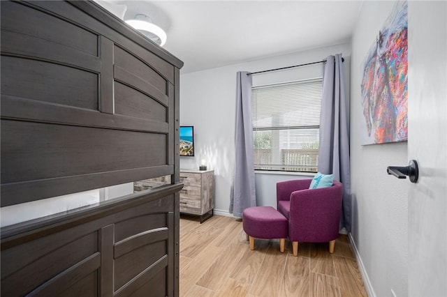 living area featuring baseboards and light wood-style floors