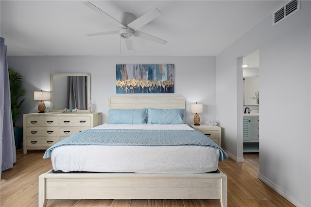 bedroom with baseboards, visible vents, ceiling fan, wood finished floors, and a sink