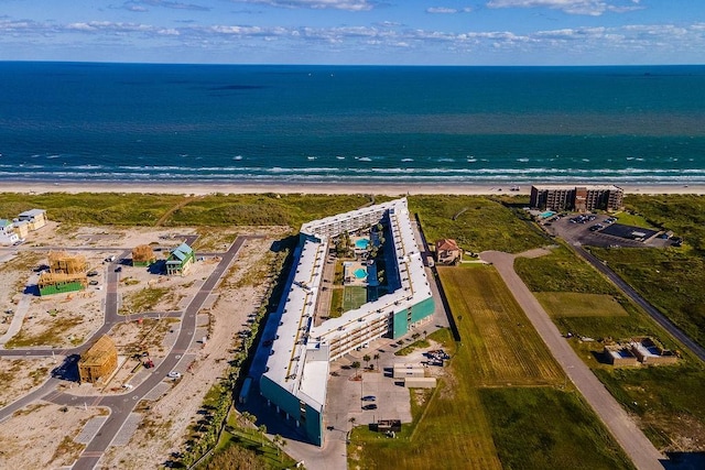 birds eye view of property with a water view and a beach view