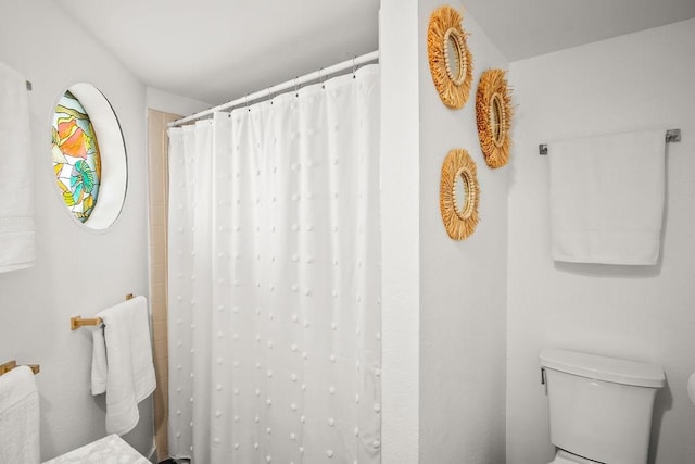 bathroom featuring curtained shower and toilet