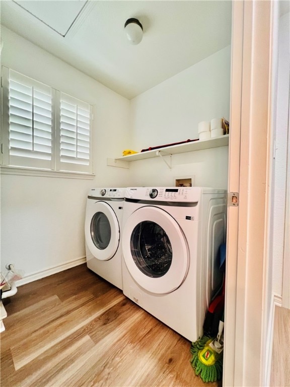 clothes washing area featuring light wood-type flooring and separate washer and dryer