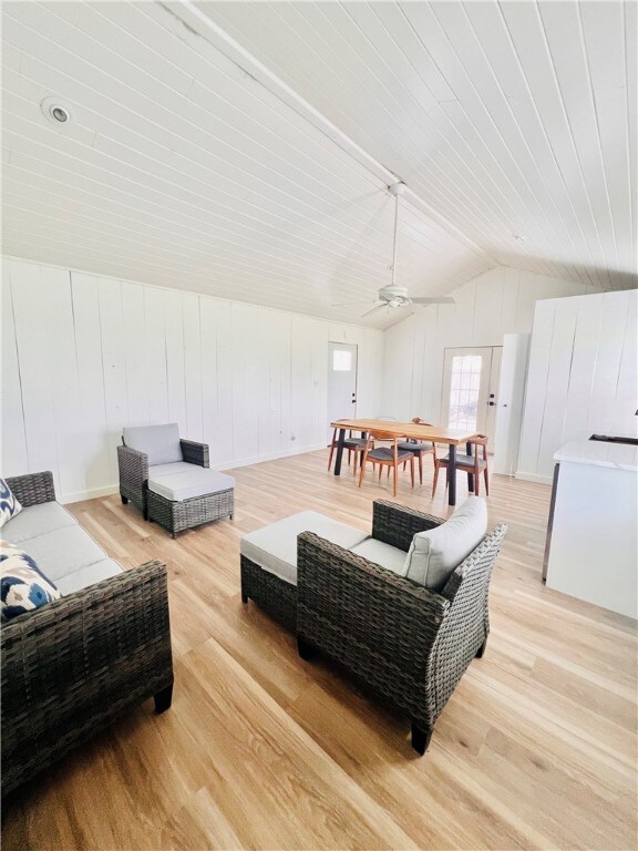 living room with light wood-type flooring, lofted ceiling, and ceiling fan