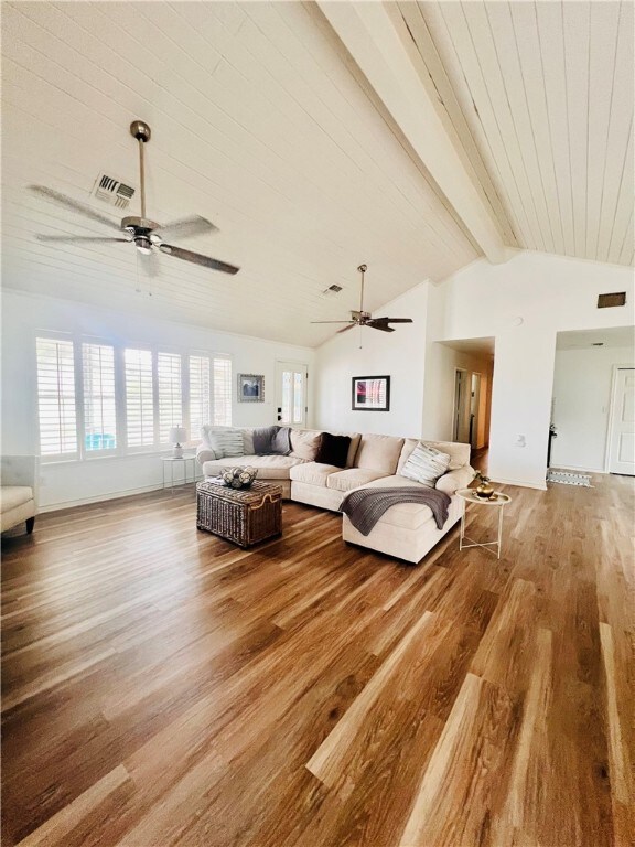 unfurnished living room featuring hardwood / wood-style floors, lofted ceiling with beams, and ceiling fan