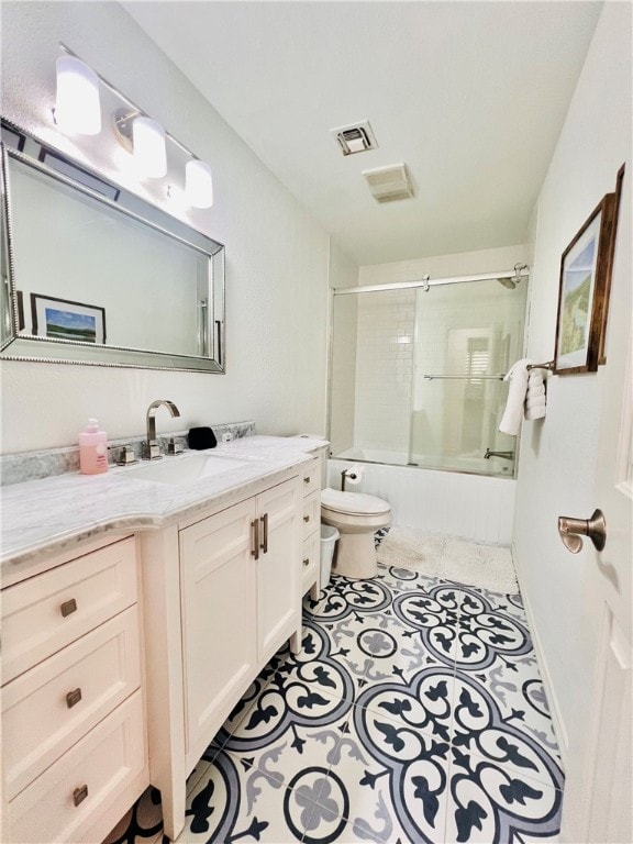 full bathroom with tile patterned flooring, vanity, combined bath / shower with glass door, and toilet