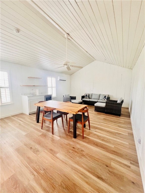 dining space featuring light wood-type flooring, a wall unit AC, lofted ceiling, and ceiling fan