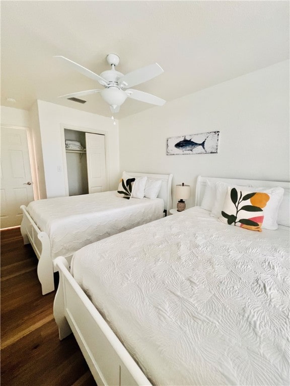 bedroom with ceiling fan, dark hardwood / wood-style floors, and a closet