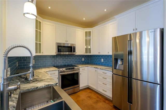 kitchen featuring white cabinets, hanging light fixtures, and appliances with stainless steel finishes