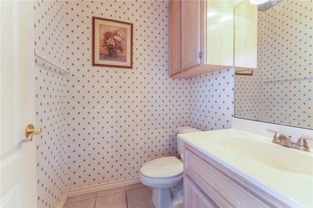 bathroom with toilet, vanity, and tile patterned flooring