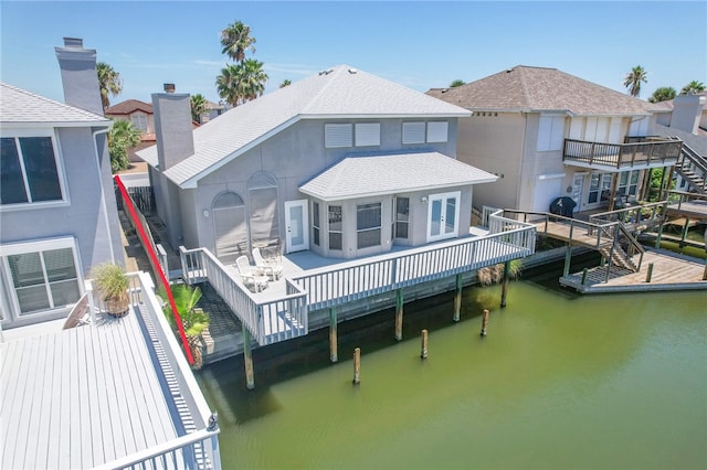 rear view of property with a patio and a deck with water view