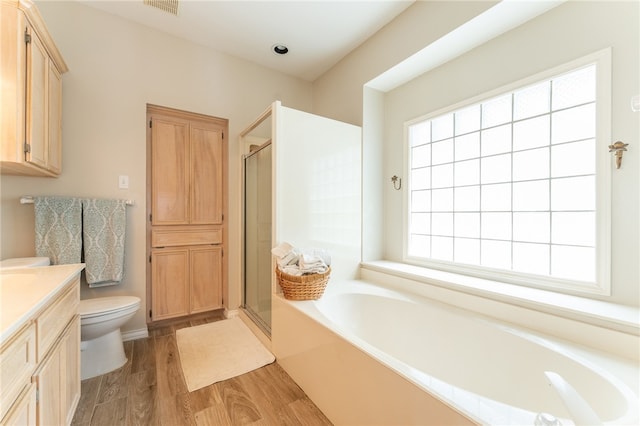 full bathroom featuring hardwood / wood-style floors, independent shower and bath, vanity, and toilet