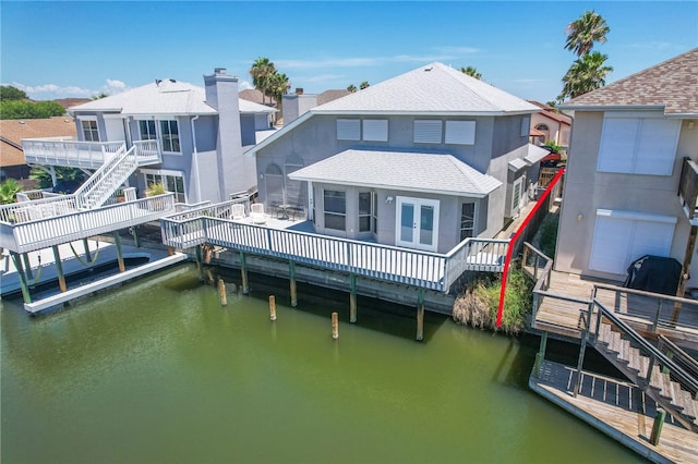 back of property featuring a deck with water view