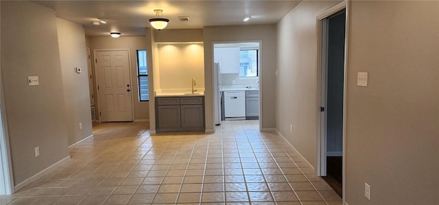 hallway featuring light tile patterned flooring and sink