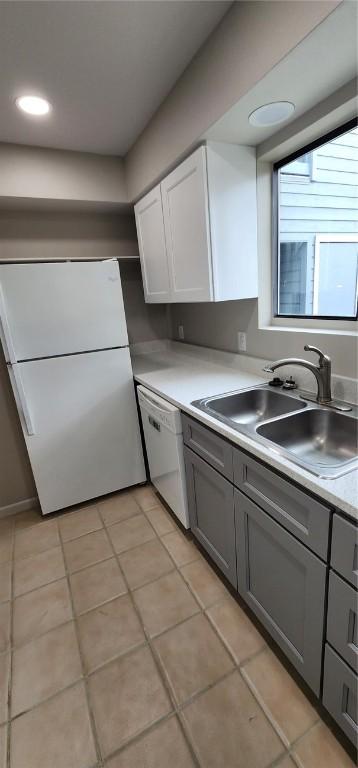 kitchen with gray cabinetry, white cabinetry, sink, white appliances, and light tile patterned flooring