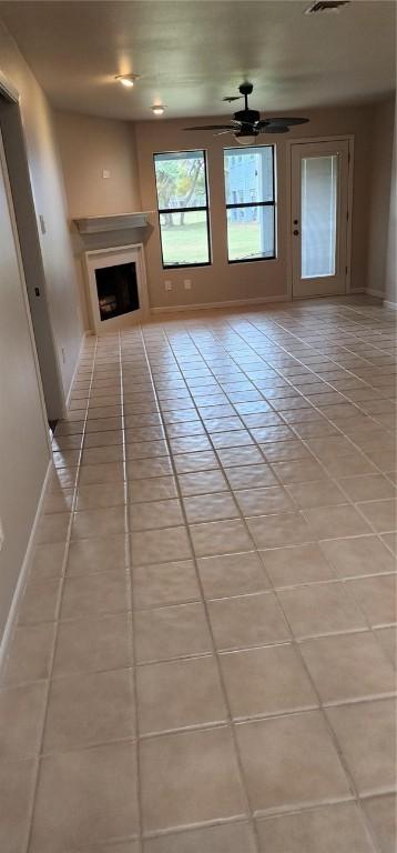 unfurnished living room with light tile patterned floors and ceiling fan