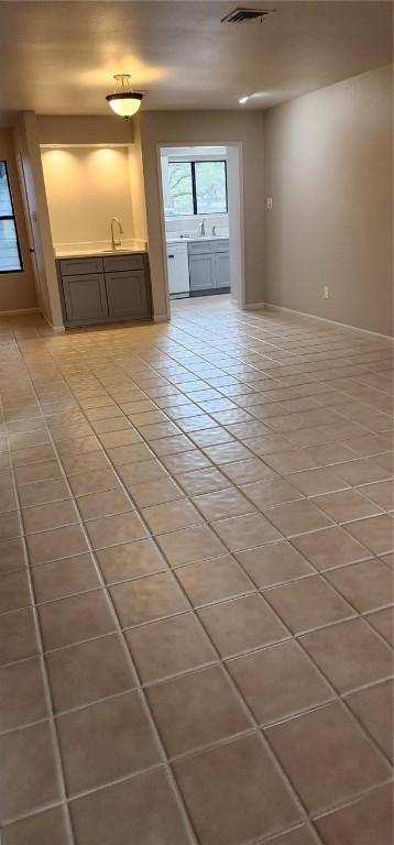 unfurnished living room with tile patterned floors and sink