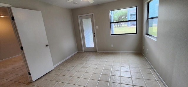 empty room featuring ceiling fan and light tile patterned flooring