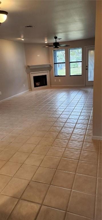 unfurnished living room featuring ceiling fan and light tile patterned floors