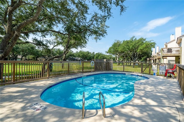 view of swimming pool with a lawn