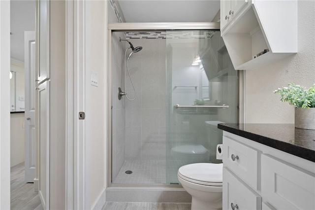 bathroom with walk in shower, vanity, and toilet