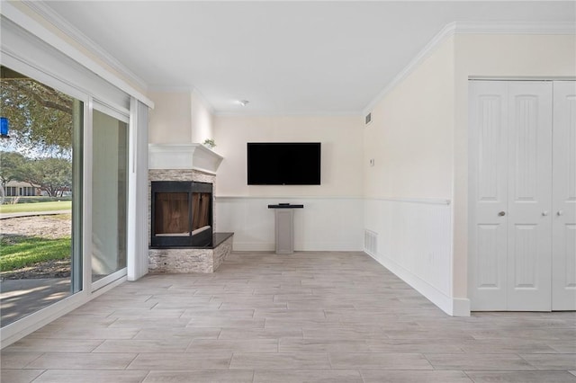 unfurnished living room featuring ornamental molding and a fireplace