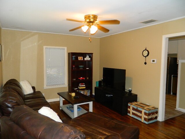 living room featuring crown molding, ceiling fan, and dark hardwood / wood-style floors