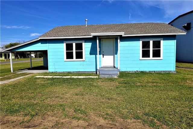 rear view of house featuring a yard and a carport