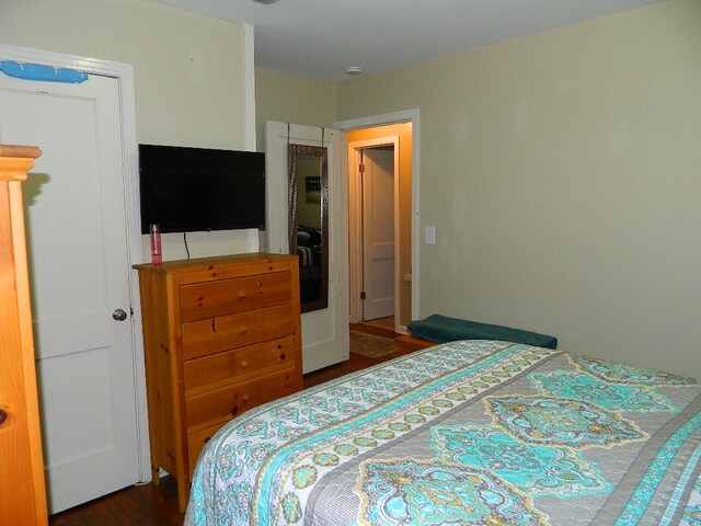 bedroom with dark hardwood / wood-style floors