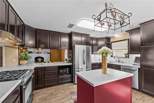 kitchen with visible vents, a sink, appliances with stainless steel finishes, light countertops, and a chandelier
