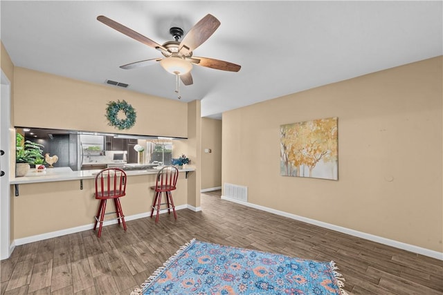 office space featuring visible vents, a ceiling fan, and wood finished floors