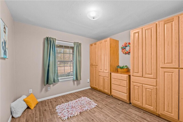 bedroom with baseboards and light wood-style floors