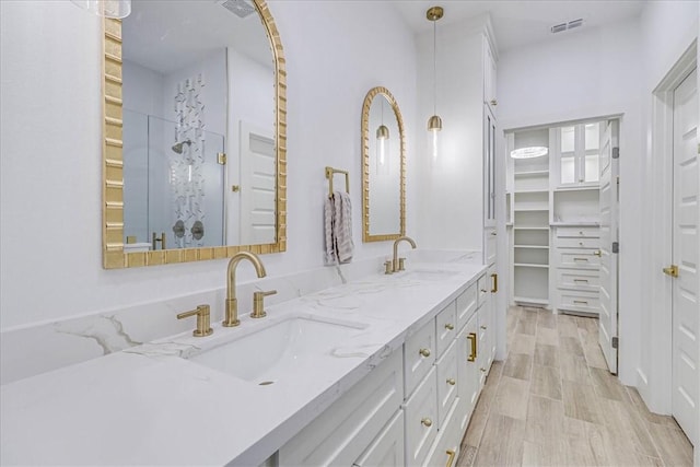 bathroom featuring a shower, wood-type flooring, and vanity