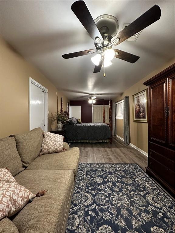 bedroom featuring dark wood finished floors, baseboards, and ceiling fan