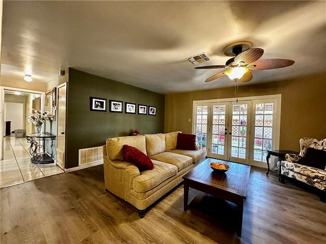 living area featuring ceiling fan, visible vents, wood finished floors, and french doors