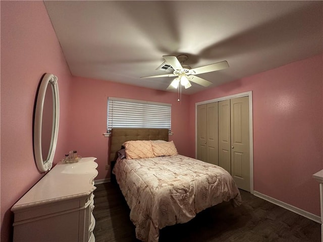 bedroom with dark wood-type flooring, a closet, ceiling fan, and baseboards