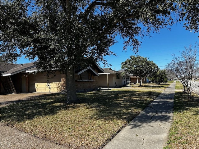 view of side of home with an attached garage, driveway, and a yard