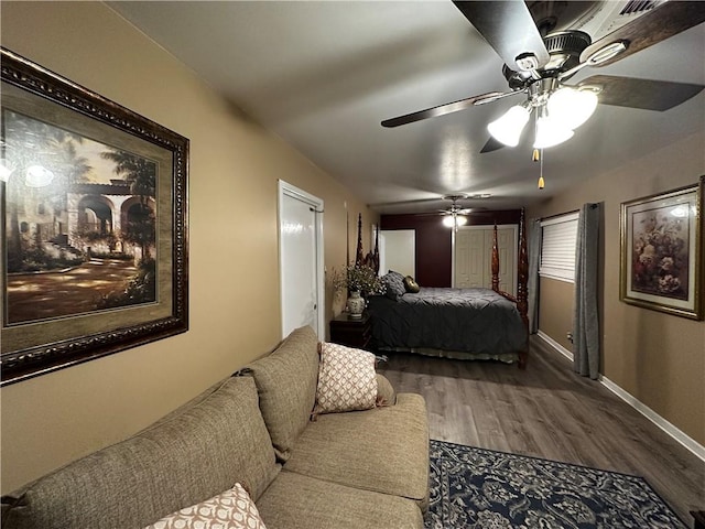 bedroom featuring wood finished floors, a ceiling fan, and baseboards