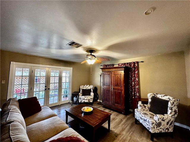 living area featuring french doors, visible vents, and wood finished floors