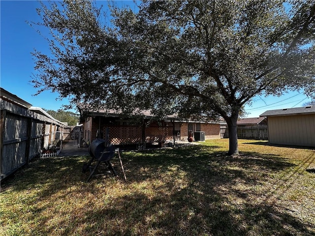 view of yard with a fenced backyard and central air condition unit